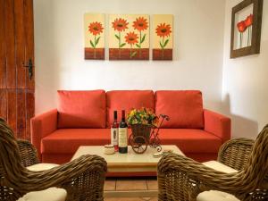 a living room with a red couch and a table at Holiday home in Malpais de Candelaria with a terrace in Bence +11 photos