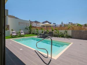 a swimming pool with a metal rail next to a building at Gournes - NewTown Residences in Gournes +30 photos