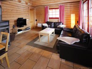 a living room with a leather couch and a table at Blockhaus mit Sauna und Kamin in Schierke in Schierke +13 photos