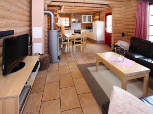 a living room with a couch and a tv and a table at Blockhaus mit Sauna und Kamin in Schierke in Schierke