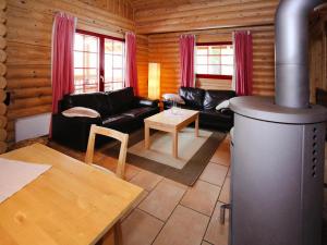 a living room with a black couch and a fireplace at Blockhaus mit Sauna und Kamin in Schierke in Schierke