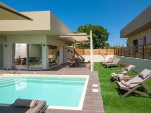 a backyard with a swimming pool and a house at Gournes - NewTown Residences in Gournes