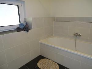 a bathroom with a tub and a window and a rug at Sunny house, 2 residential units in Postmünster +34 photos