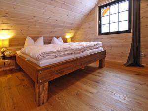 a bed in a log cabin with a window at Cottage, Schierke in Schierke