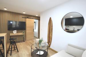 a living room with a glass table and a mirror at Notel Club - Apt Somo Surf in Somo