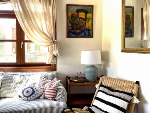 ein Wohnzimmer mit einer Couch und einem Fenster in der Unterkunft Romantic Pergamonto Cottage, private Pool & SeaView in Skopelos