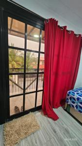 a room with a window with a red curtain at Jolie Joes Standard Room with Private Bathroom in Tagudin