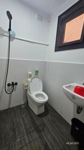 a bathroom with a toilet and a sink at Jolie Joes Standard Room with Private Bathroom in Tagudin