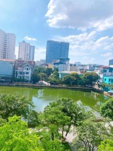 a city skyline with a pond in the foreground at Sunny Hotel in Hanoi