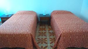 two beds sitting next to each other in a room at Casa Almirante Reis - Perfect Location & Rooftop in Olhão +17 photos