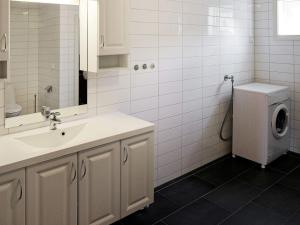 a bathroom with a sink and a washing machine at 15 person holiday home in Treungen in Treungen