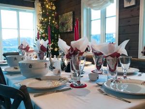 a christmas table with a christmas tree in the background at 15 person holiday home in Treungen in Treungen