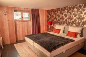 a bedroom with a large bed with red pillows at Chalet de luxe - Alpes française in Colmars