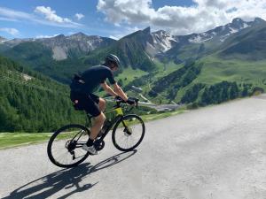 a man riding a bike down a road at Chalet de luxe - Alpes française in Colmars