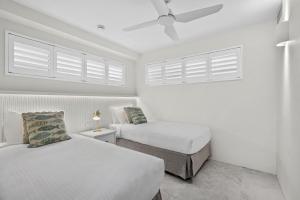 ヌーサヘッズにあるFrench Quarter by Stay Noosaのベッド2台と天井ファン付きの寝室 +12枚の写真