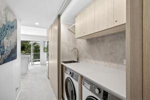 ヌーサヘッズにあるFrench Quarter by Stay Noosaのキッチン(洗濯機、乾燥機付)