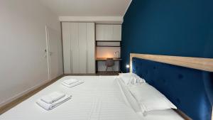 a bedroom with a large white bed with blue walls at ELIZA Apartments - powered by NEO - private parking in Timişoara