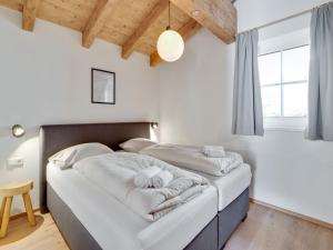 two beds in a bedroom with white walls and a window at Modern Chalet in Mühlbach am Hochkönig near Ski Area in Mühlbach am Hochkönig