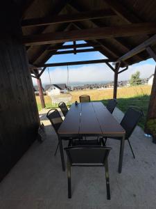 a wooden table and chairs under a pavilion at LakeHome&Spa nad Jeziorem Czorsztyńskim in Kluszkowce