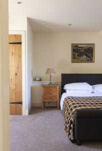 a bedroom with a bed and a table with a lamp at Old Mill Cottage in Kelso