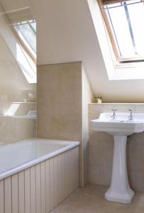 a bathroom with a sink and a bath tub and a skylight at Old Mill Cottage in Kelso