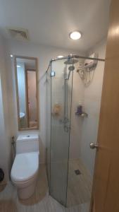 Un baño con inodoro y ducha de cristal. en Ohana Suites 2 Studio Lot 8 Condo Near Ayala Cebu City with fast Wifi and Netflix, en Cebú