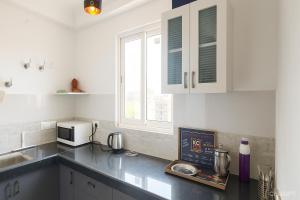a kitchen with a counter top with a microwave at VVIP Address Homestay Jagatpura Jaipur Luxury Stay in Jaipur
