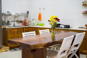 a kitchen with a wooden table with a vase of flowers at King bed private room in Khu Chi Lăng