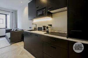 eine Küche mit einem Waschbecken und einem Sofa in einem Zimmer in der Unterkunft Un Madrid histórico para 4, en Plaza del Carmen E2 in Madrid + 17 Fotos