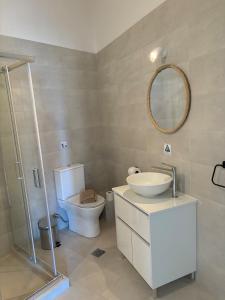 a bathroom with a toilet and a sink and a mirror at Aegina Heights in Aegina Town +6 photos