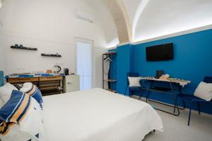 ein Schlafzimmer mit einem Bett und einer blauen Wand in der Unterkunft Dimora dei Colori - Serene Blue in Bari + 9 Fotos