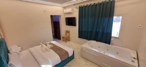 a bedroom with a bed and a tub and a window at Anubis kingdom pyramids view in Cairo +88 photos