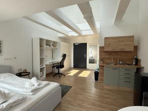 a bedroom with a bed and a desk and a kitchen at Central Urban Studio in Wiener Neustadt