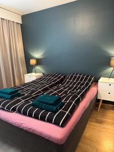 a bedroom with a bed with two green towels on it at City center apartment in Rovaniemi
