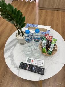 a white table with a remote control and water bottles at Evergreen Bac Giang apartment in Bắc Giang