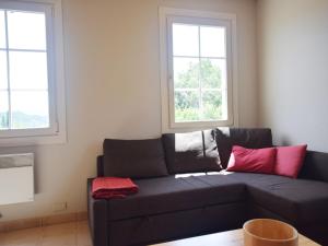 Sofá negro en una sala de estar con 2 ventanas en Peaceful Holiday Home in Les Vans, Ardeche with Pool, en Les Vans