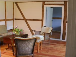 a living room with chairs and a table with flowers on it at Holiday home Mönke's Kate near seabeach in Mönkebude