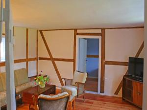 a living room with a couch and chairs and a television at Holiday home Mönke's Kate near seabeach in Mönkebude