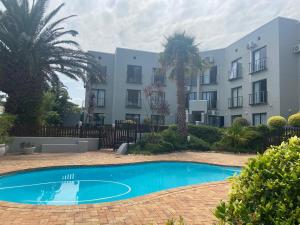 an empty pool in front of a building at Modern Sea and Mountain View Apartment - Gordon's Bay in Gordonʼs Bay