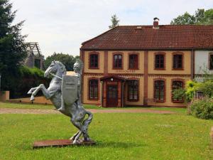 a statue of a man riding a horse in front of a house at Holiday home Oliver, Wendorf in Wendorf