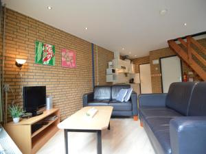 a living room with a couch and a tv at Dine & Unwind Vacation Spot in Stramproy