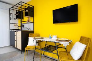 ein Esszimmer mit gelber Wand, Tisch und Stühlen in der Unterkunft Dimora dei Colori - Yellow Light in Bari + 12 Fotos