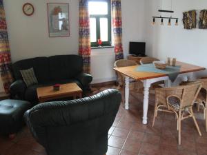 un soggiorno con un divano, un tavolo e delle sedie di Comfortable apartment in quaint holiday village a Barlin