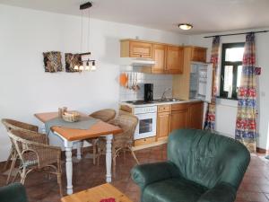 una cucina e una sala da pranzo con tavolo e sedie di Comfortable apartment in quaint holiday village a Barlin