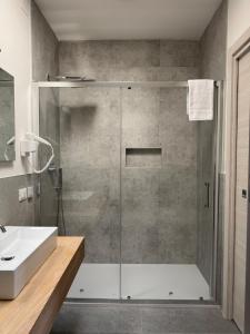 a bathroom with a glass shower with a sink at Dormi-RE 2 in Reggio Emilia +6 photos