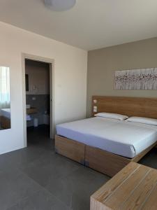 a bedroom with a large bed and a bathroom at Dormi-RE 2 in Reggio Emilia