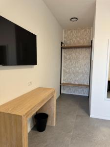 a room with a table and a flat screen tv on the wall at Dormi-RE 2 in Reggio Emilia
