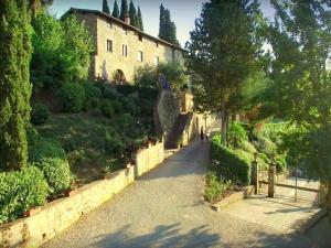 una persona caminando por un camino delante de un edificio en Attractive apartment in typical Tuscan style, en Figline Valdarno