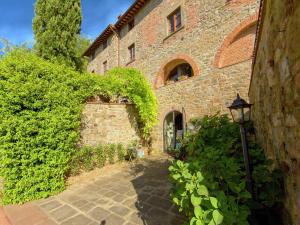 Un edificio de ladrillo con una farola delante. en Attractive apartment in typical Tuscan style, en Figline Valdarno