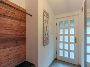 pasillo con puerta y pared de madera en Modern Apartment in Kirchdorf with Garden, en Kirchdorf in Tirol